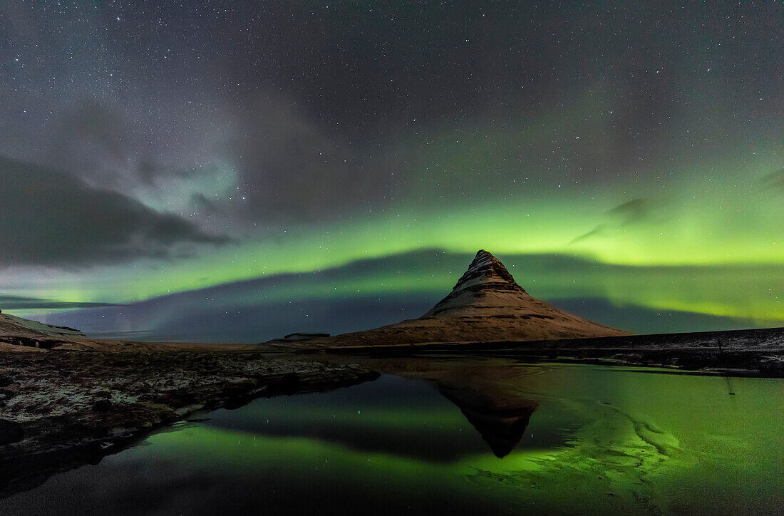 Aurora Borealis spiegelt sich unter Kirkjufell (auch bekannt als Kirchenberg) auf der Halbinsel Snaefellsnes im Westen Islands