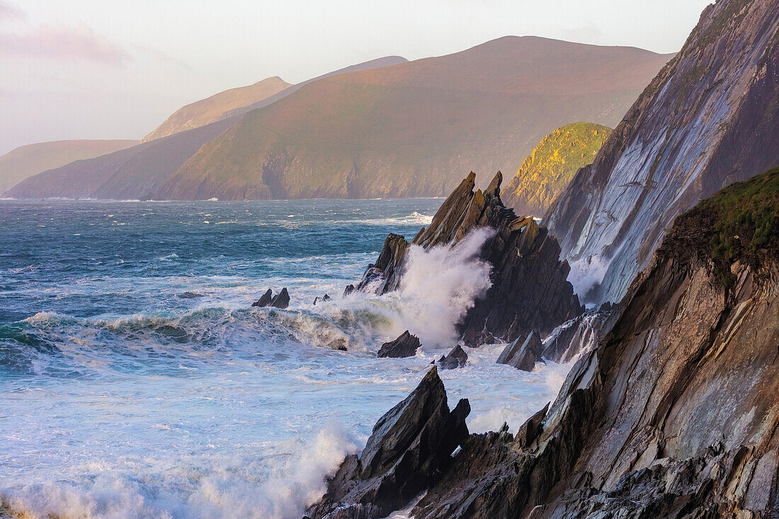 Wellen krachen gegen Klippen auf Dunmore Head mit Blasket Islands auf der Dingle-Halbinsel, Irland