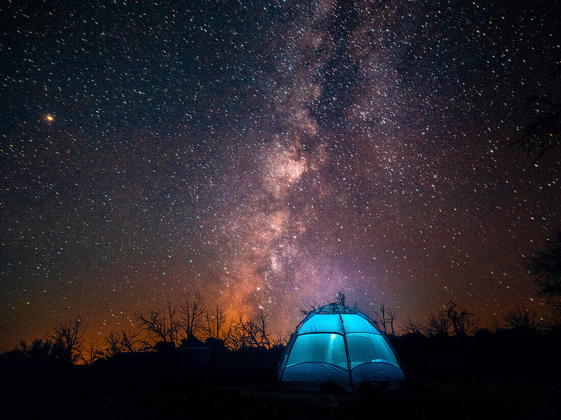 USA, Kalifornien, Mojave-Wüste. Ein beleuchtetes Zelt vor einem Sternenhimmel und der Milchstraße.