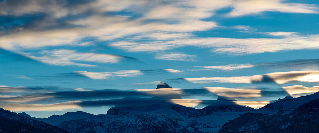 Dämmerungsschatten, die von Teton Peaks vor Sonnenaufgang geworfen werden. Altocumulus lenticularis-Wolken sind ebenfalls sichtbar.