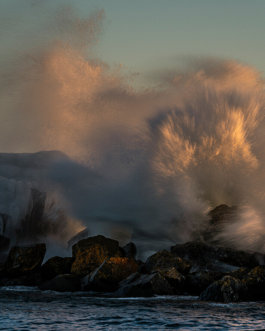 USA, Minnesota, Lake Superior. Lake waves breaking on rocks at sunset