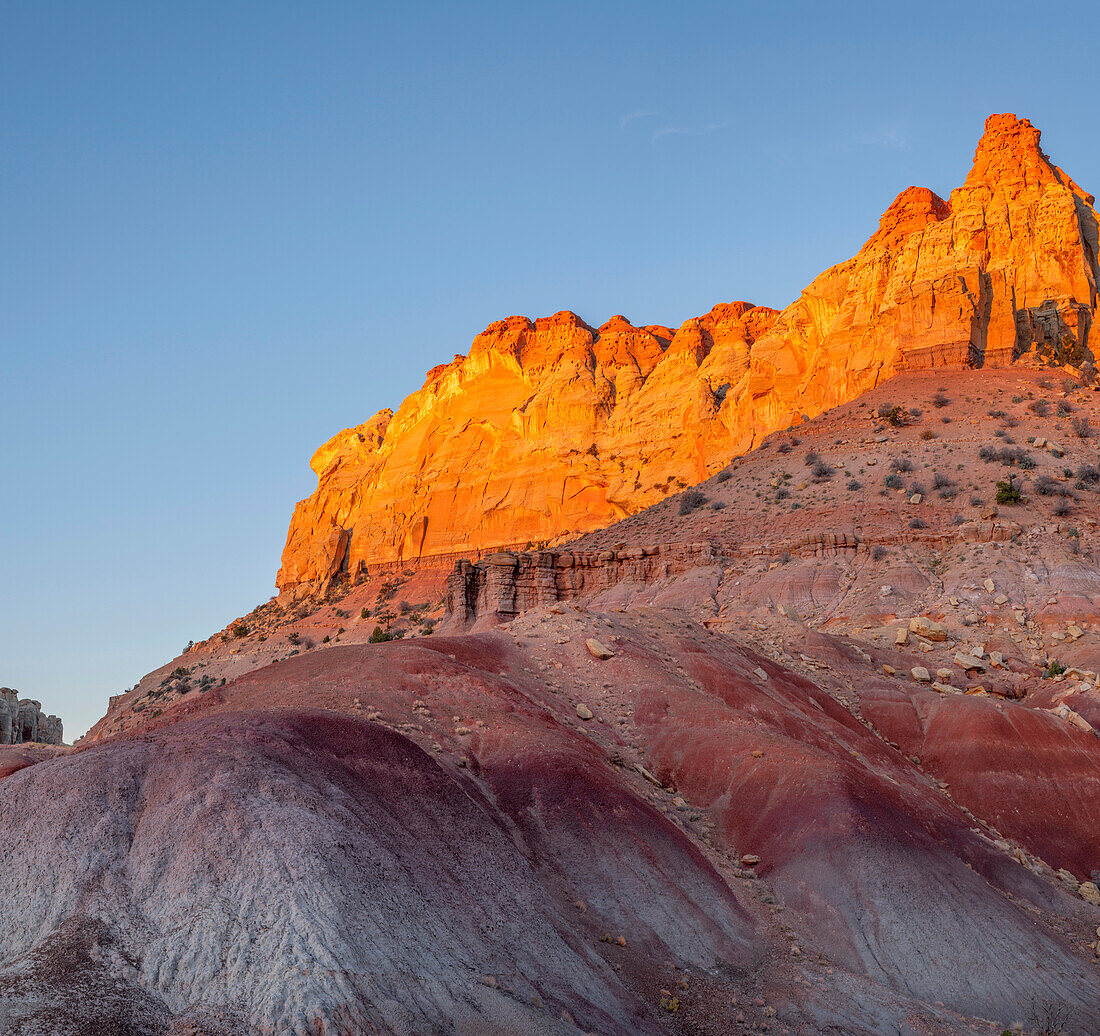 USA, Utah. Grand Staircase Escalante National Monument, sunrise on sandstone peaks of the Circle Cliffs above soft, eroded, clay sediments.