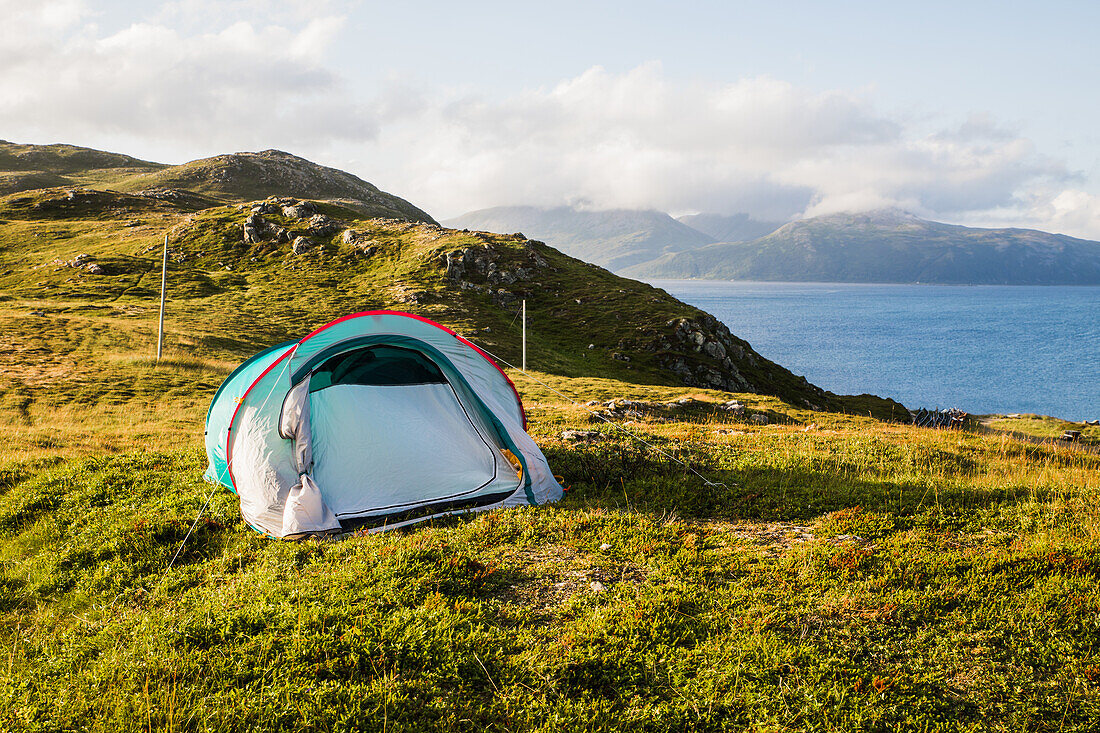 Norwegen, Lofoten, Zelt im Sonnenuntergang über dem Fjord