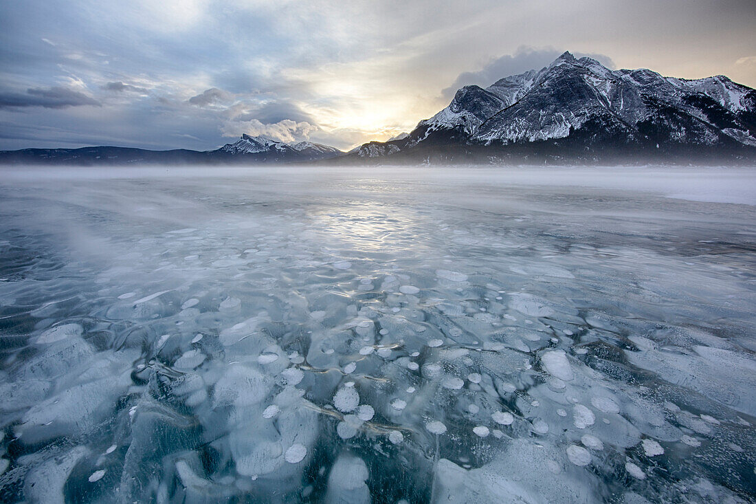 Kanada, Alberta, Abraham Lake. Wintersonnenaufgang über See und Berg Michener