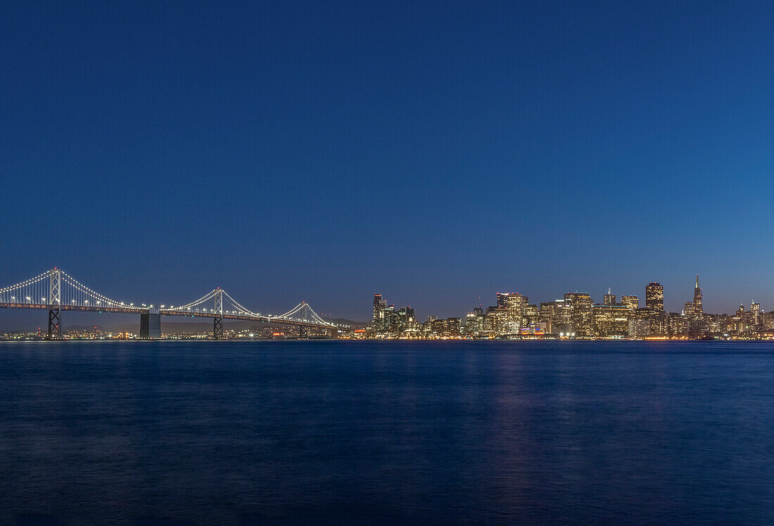 USA, Kalifornien, San Francisco, Bay Bridge und Skyline der Innenstadt in der Dämmerung