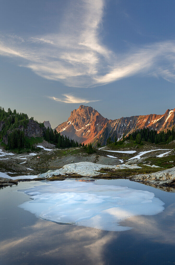 Teilweise aufgetauter Tümpel, Yellow Aster Butte Basin. American Border Peak ist in der Ferne zu sehen. Mount Baker Wilderness, North Cascades, Bundesstaat Washington