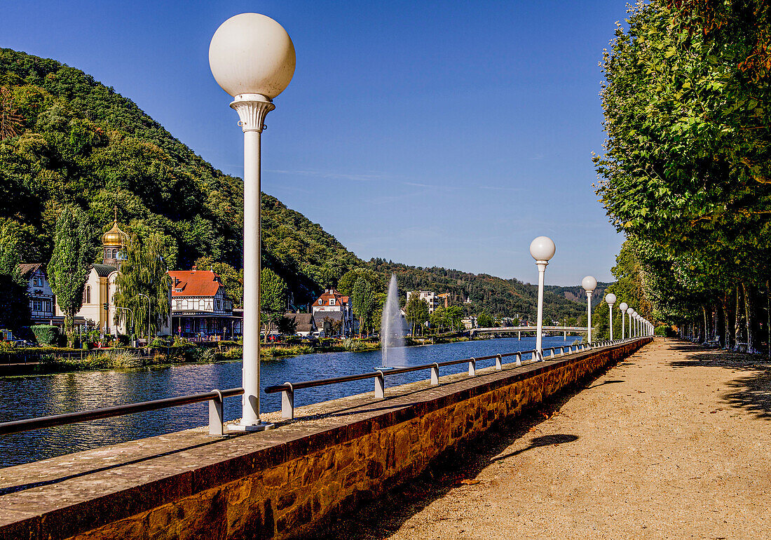 Kurpark promenade on the Lahn with a view of the Russian Church on the waterfront, Bad Ems, Rhineland-Palatinate, Germany