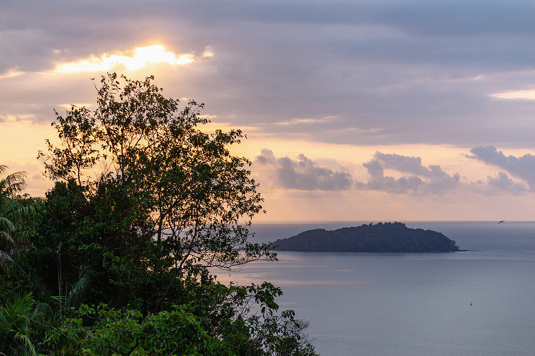 dramatic evening sky with sunset behind clouds and view of Bom Bom Island off Príncipe Island in West Africa