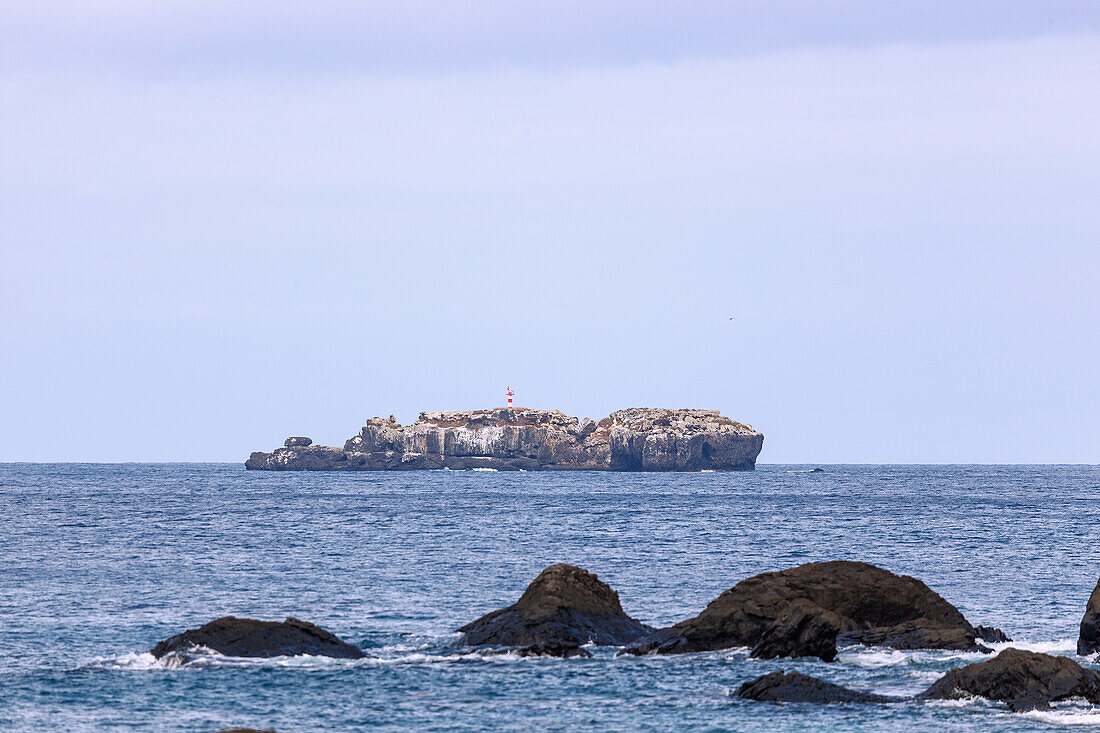 Rocky island with a lighthouse off the northeast coast of the island of Príncipe in West Africa