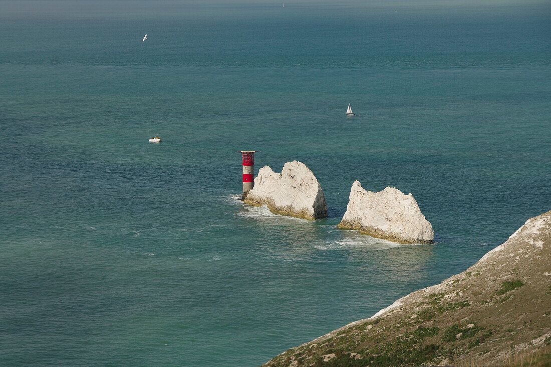 Blick auf die Needles auf der Isle of Wight bei Freshwater mit Leuchtturm und kleinen Booten auf dem Wasser, Südengland, England, Großbritannien, Europa