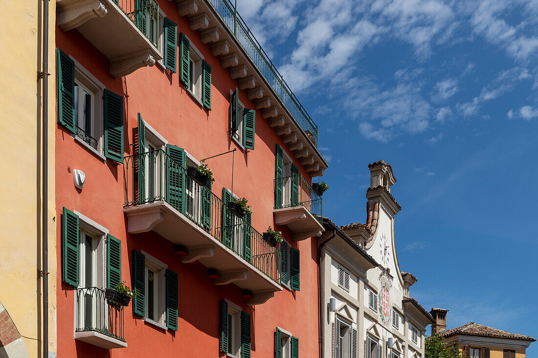Wohnhaus mit roter Fassade und Rathaus, im historischen Zentrum von Neive, Langhe, Piemont, Italien.