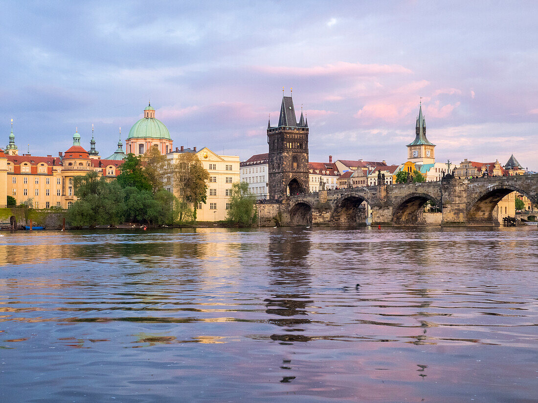 Czech Republic, Prague. View of the Lesser town bridge tower and clock tower on the Vltava river.