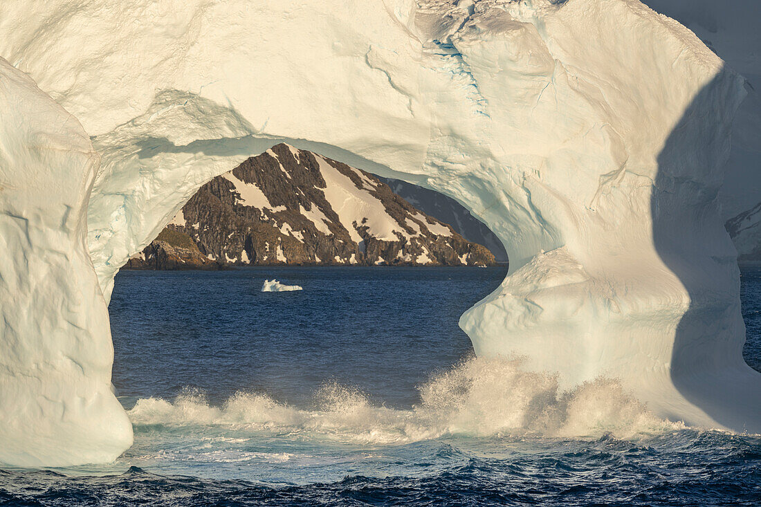 Antarktis, Insel Südgeorgien, Coopers Bay. Eisbergbogen und Berge bei Sonnenaufgang