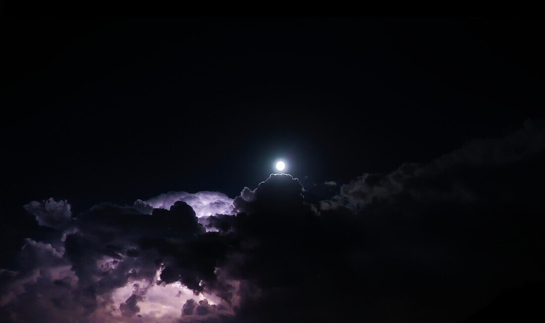 Beautiful Lightning and Full Moon and Clouds at Night in Lugano, Ticino, Switzerland.