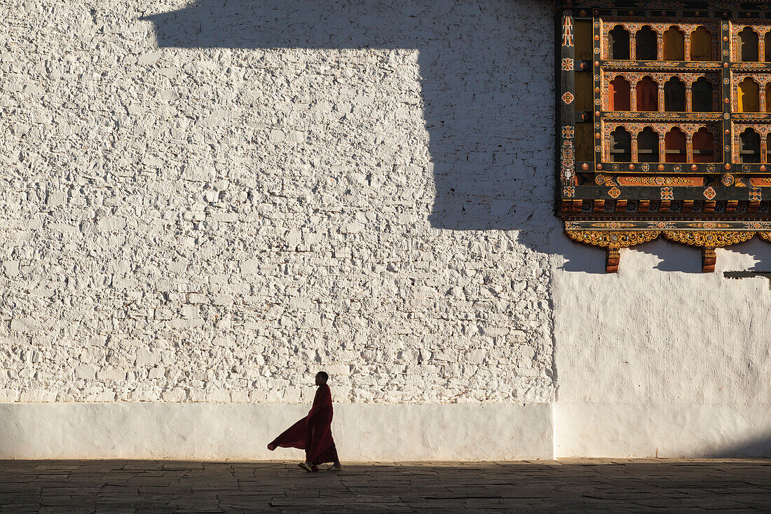 Mönch geht durch den Innenhof des Rinpung Dzong (Kloster), auch Paro Dzong genannt, in Bhutan.
