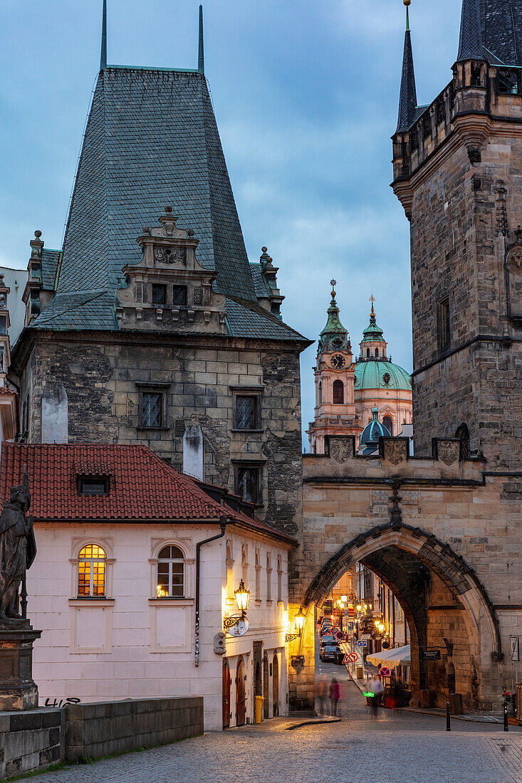 Arch of Lesser Town Bridge Tower on Charles Bridge with St. Nicholas Church in Prague, Czech Republic