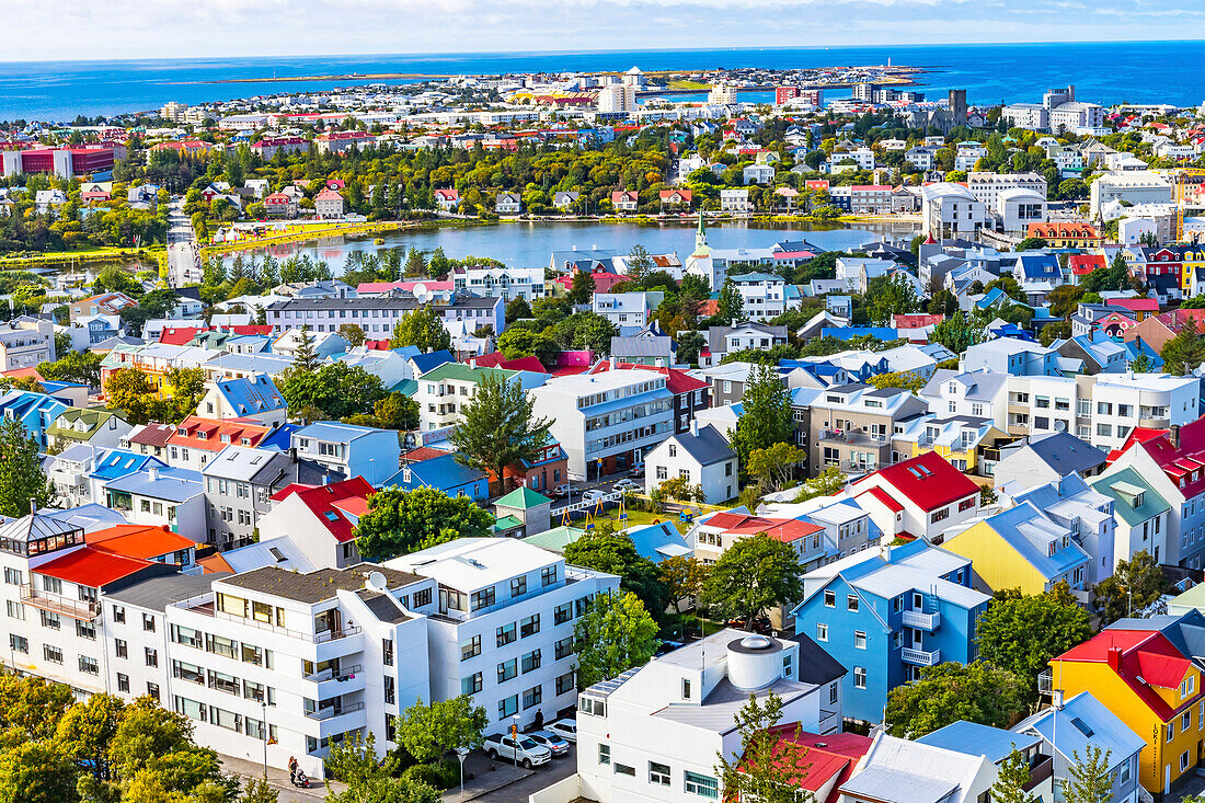 Small Tjornin Lake blue Ocean Sea Colorful blue red white green Houses Streets, Reykjavik, Iceland.