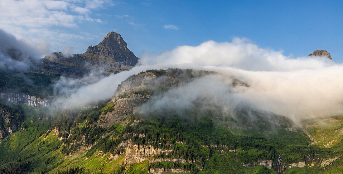 Rollende Nebelwolken mit Heavy Runner und Reynold Mountains am Logan Pass im Glacier National Park, USA