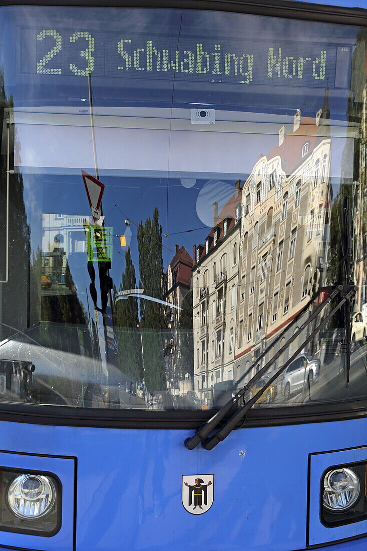 Straßenbahn nach Schwabing Nord wartet an der Trambahn-Station Münchner Freiheit, in der Reflektion das Dülferhaus, Leopoldstrasse, Schwabing, München, Oberbayern, Bayern, Deutschland
