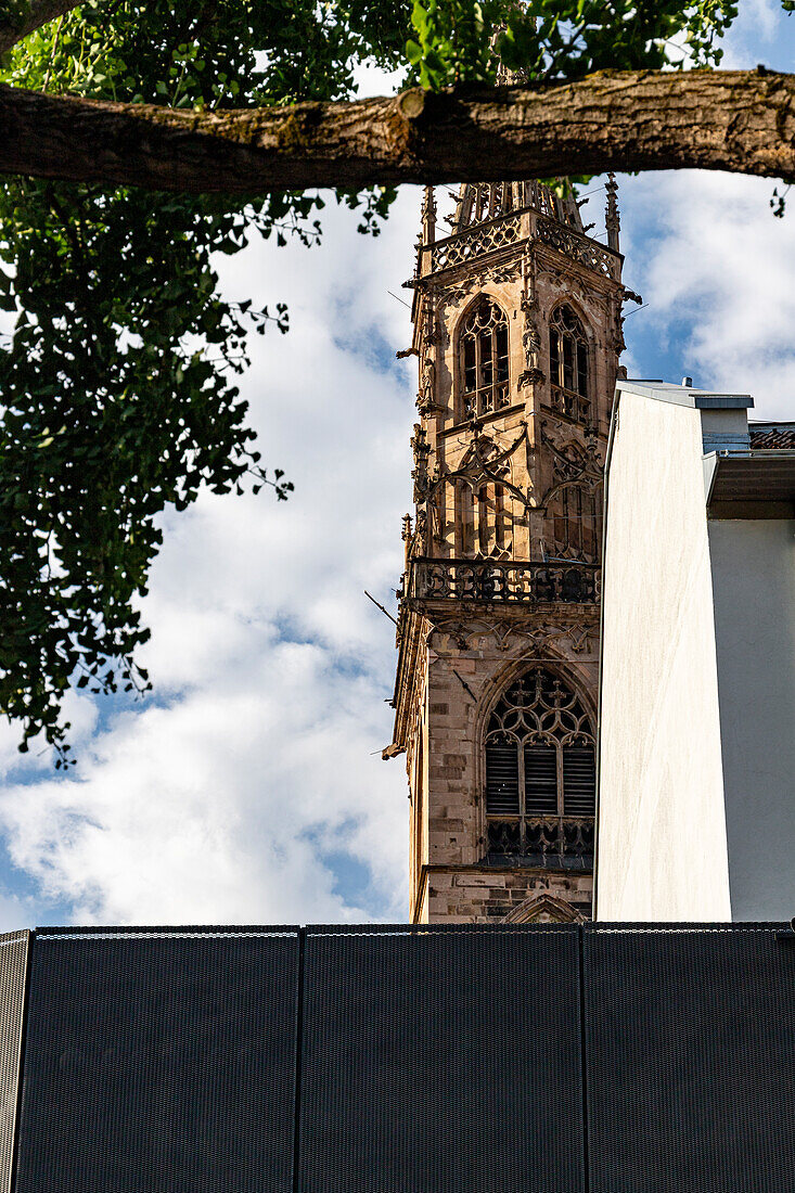 Cathedral bell tower under clouded sky, Bolzano, South Tyrol, Italy