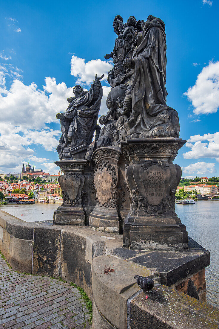 Statuen der Madonna mit den Heiligen Dominikus und Thomas von Aquino auf der Karlsbrücke mit Blick auf die Burg in Prag, Tschechische Republik
