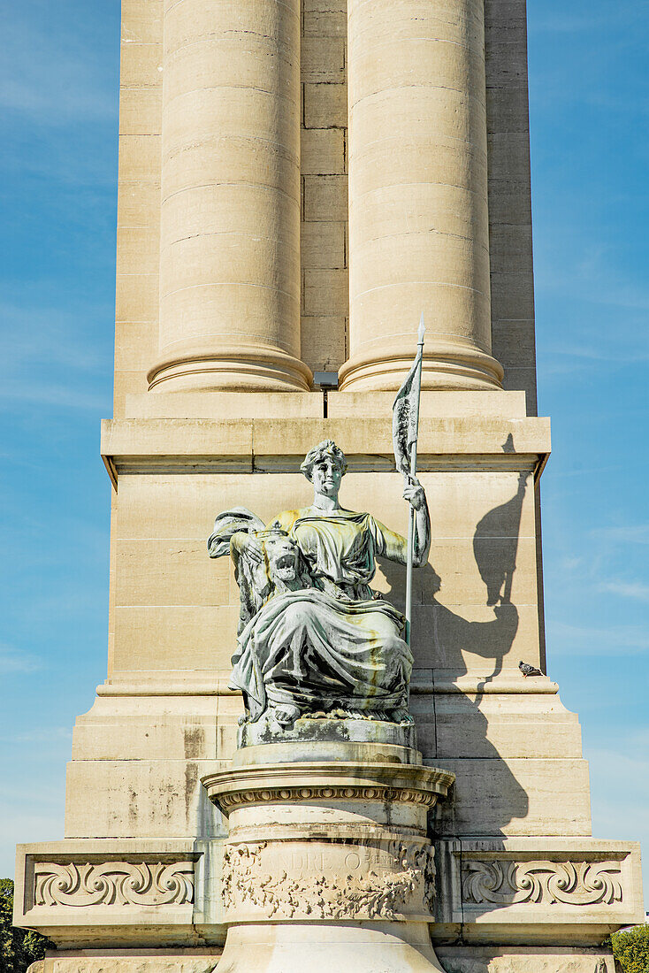 Statue sitting at bottom of column at the Monument du Cinquantenaire in Brussels, Belgium