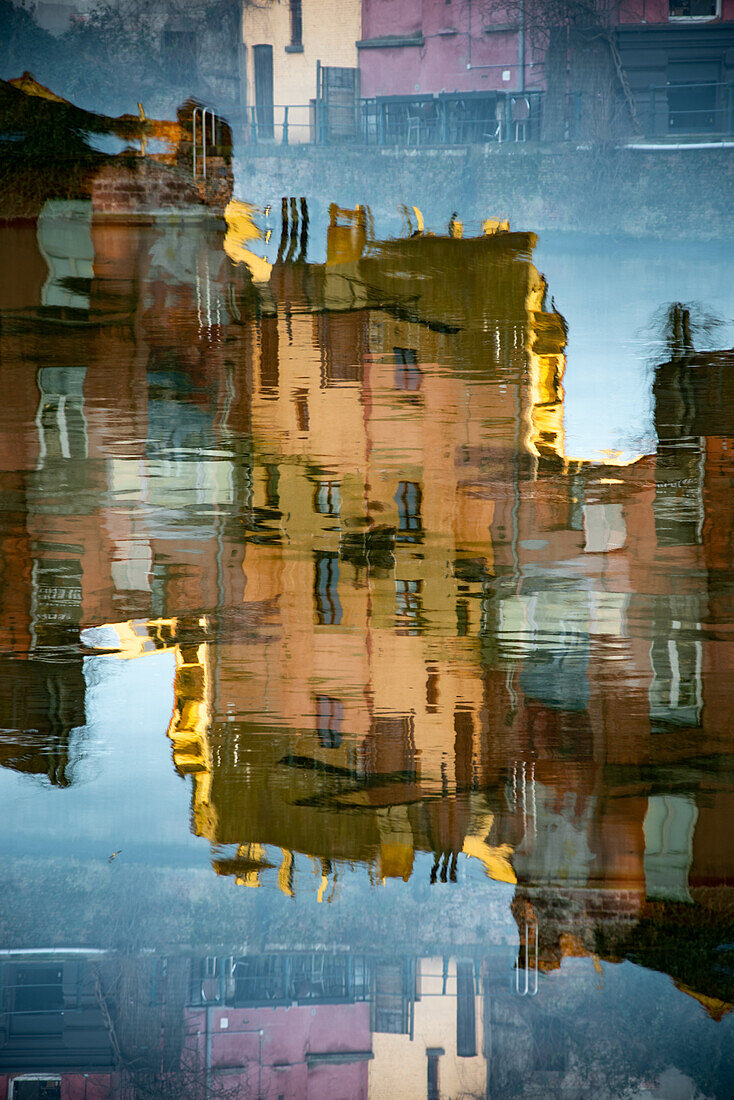 Double exposure photo of buildings reflected in water in Gent, Belgium