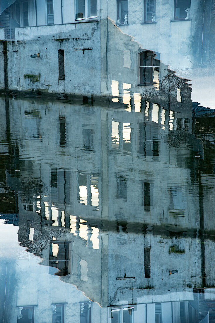 Doppelbelichtungsfoto von Gebäuden, die sich in Gent, Belgien, im Wasser spiegeln