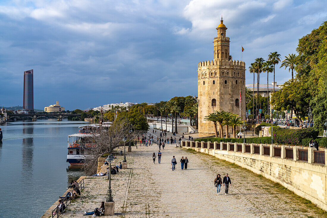 Uferpromenade am Fluss Guadalquivir mit dem historischen Turm Torre del Oro in Sevilla, Andalusien, Spanien  