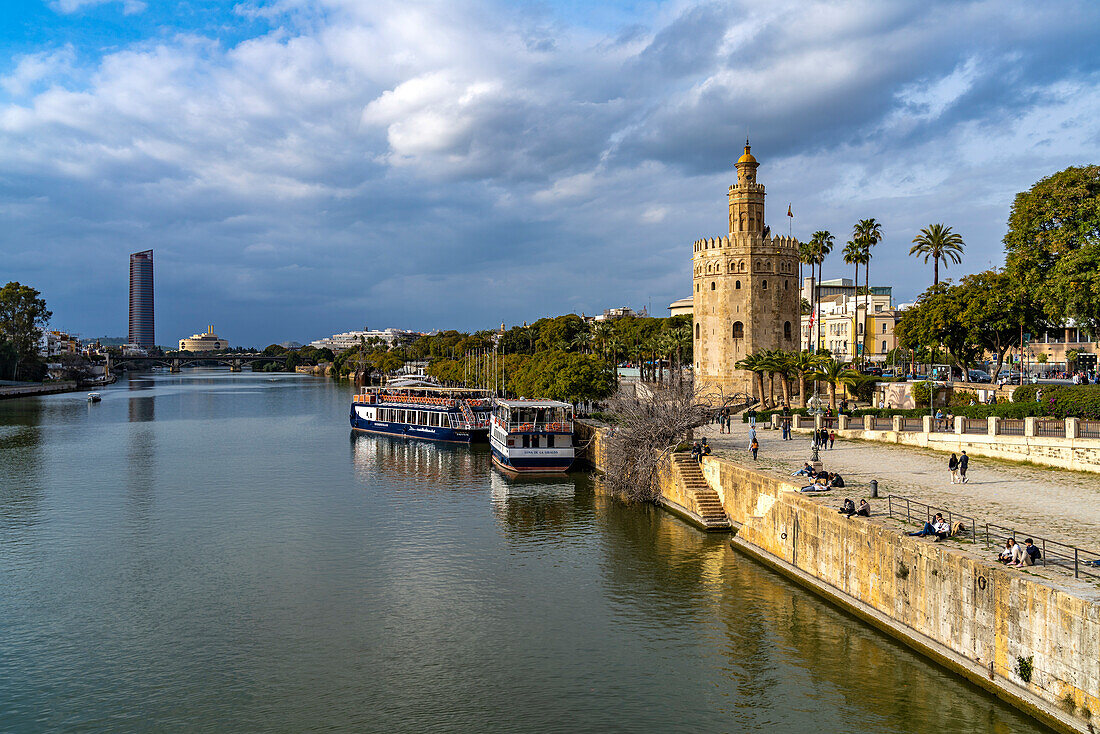 Am Ufer des Fluss Guadalquivir mit dem historischen Turm Torre del Oro in Sevilla, Andalusien, Spanien  