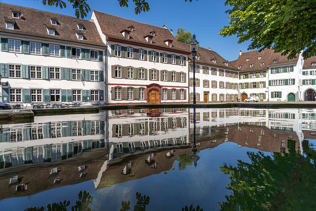 Domherrenhäuser spiegeln sich im Brunnen am Münsterplatz in Basel, Schweiz, Europa