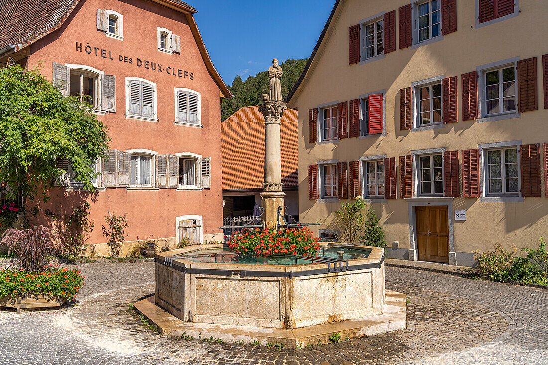 The Fontaine du Mai fountain in the historic old town of Saint-Ursanne, Switzerland, Europe