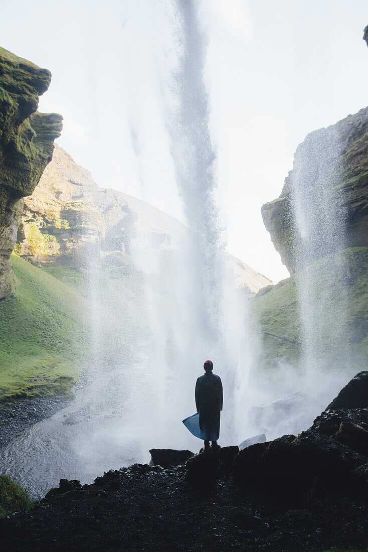 Silhouette des Menschen hinter dem Wasserfall Kvernufoss in Island
