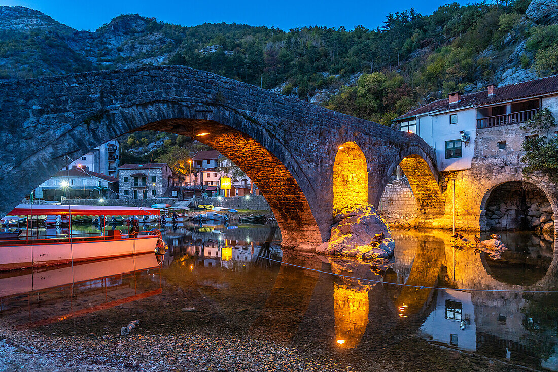 The Old Bridge Stari Most over the Crnojevic River in Rijeka Crnojevica at dusk, Montenegro, Europe