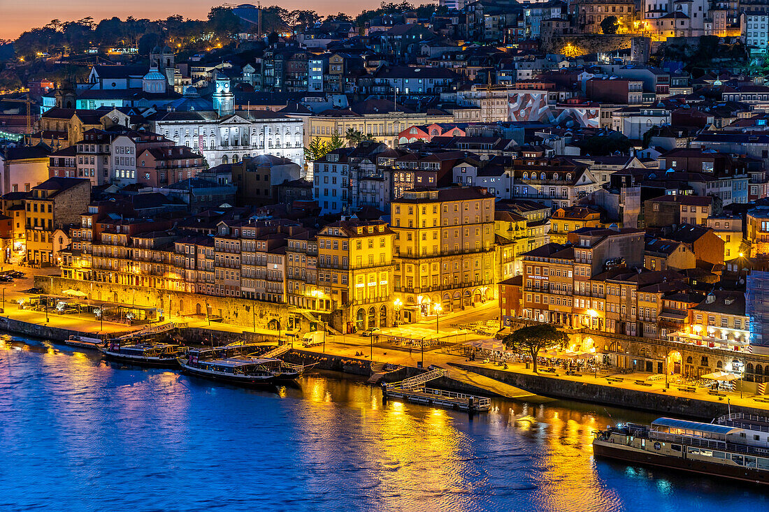 View across the Douro River to the Cais de Ribeira and the old town of Porto at dusk, Portugal, Europe