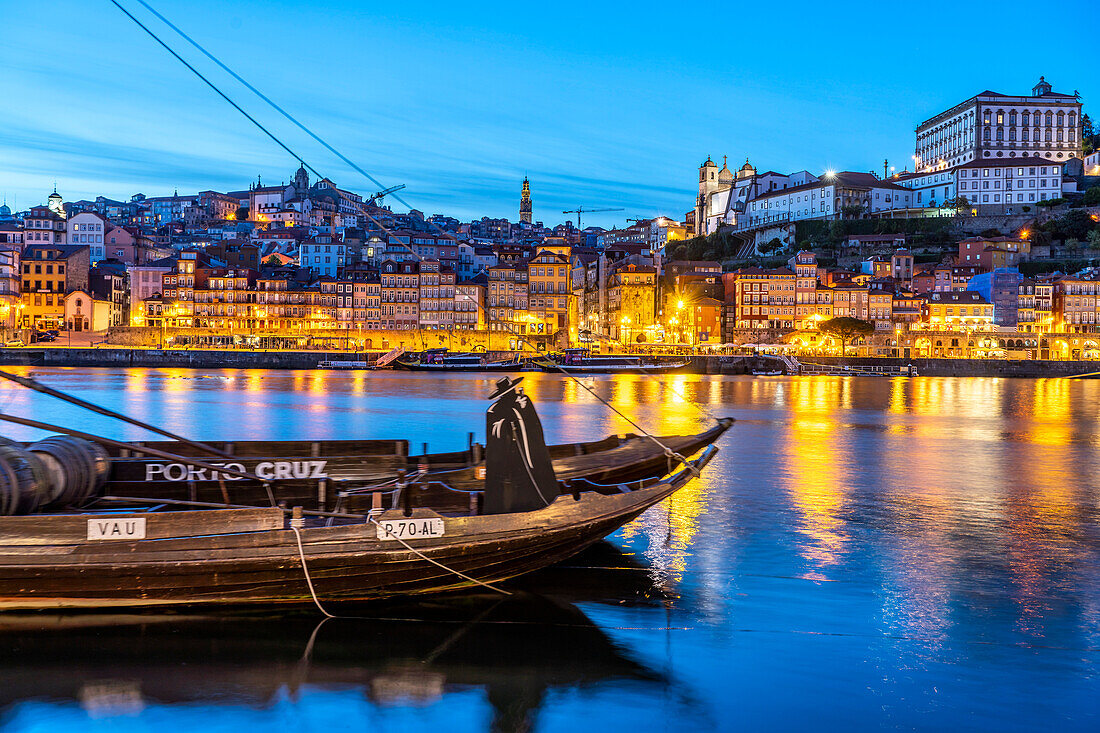Blick über die traditionellen Rabelo Boote am Douro Ufer in Vila Nova de Gaia auf die Altstadt von Porto in der Abenddämmerung, Vila Nova de Gaia, Portugal, Europa