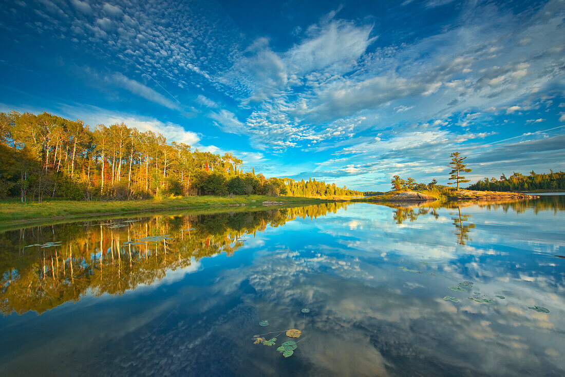 Kanada, Ontario, Kenora. Wolken spiegeln sich bei Sonnenuntergang im mittleren See wider