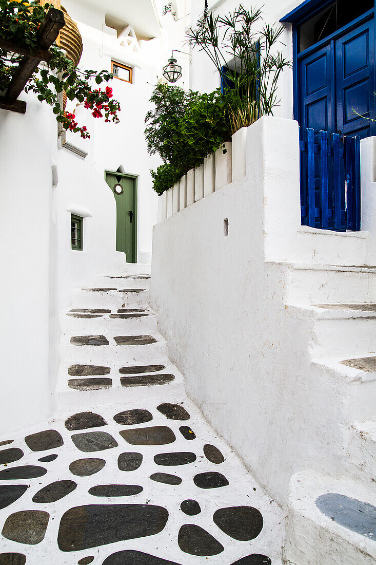 Mykonos, Griechenland. Terrasse und Treppe aus Felsen und Stuck führen zu bemalten Türen
