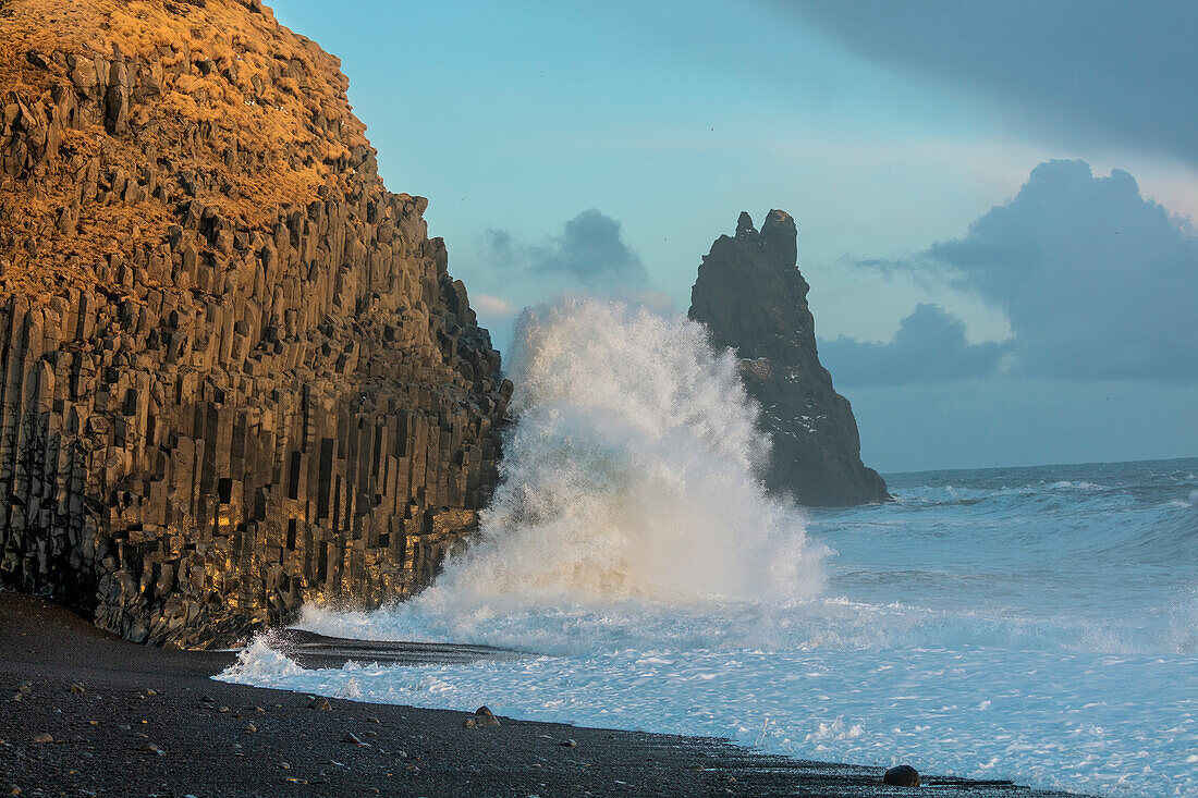 Wellen aus dem Nordatlantik stürzen in Basaltsäulen am Schwarzen Strand in der Nähe von Vik, Island