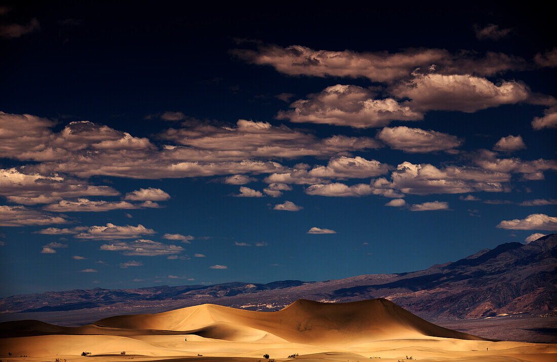 Dicke Wolken beschatten eine Sanddünen