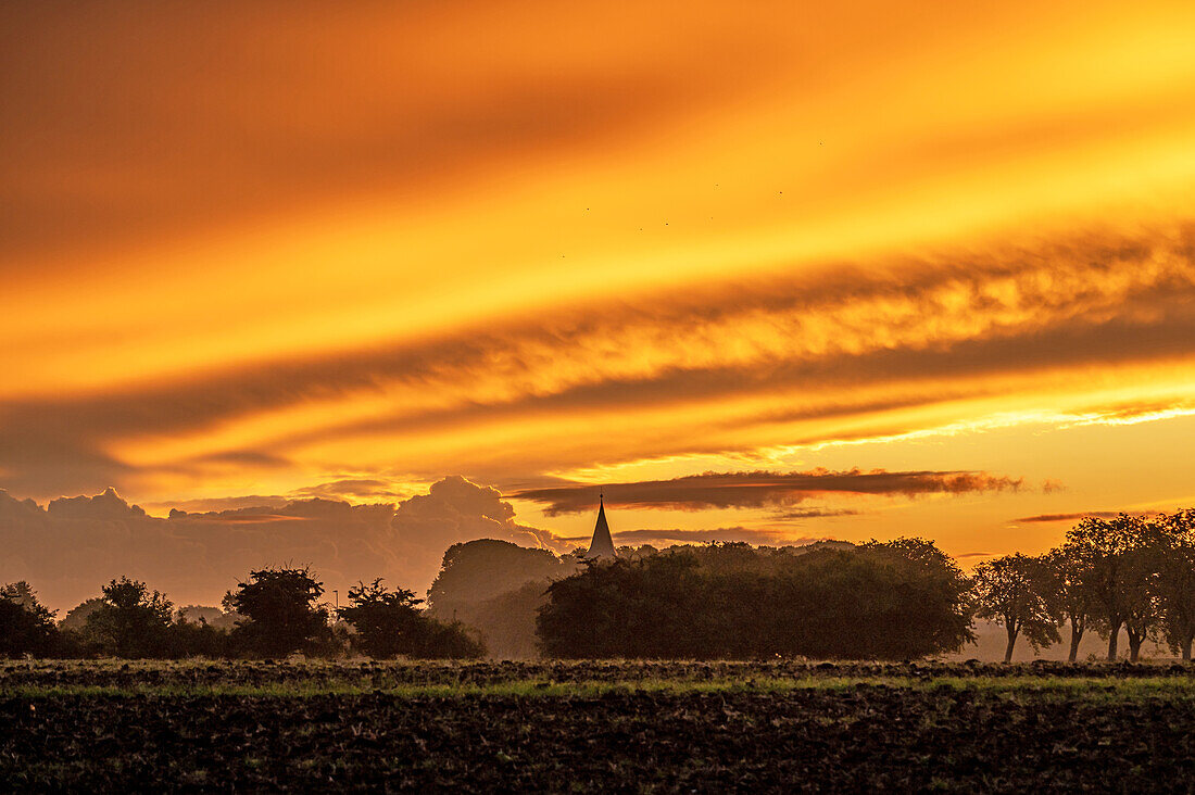 Imposant gefärbter Himmel zum Sonnenaufgang in Neukirchen in Ostholstein, Schleswig-Holstein, Deutschland