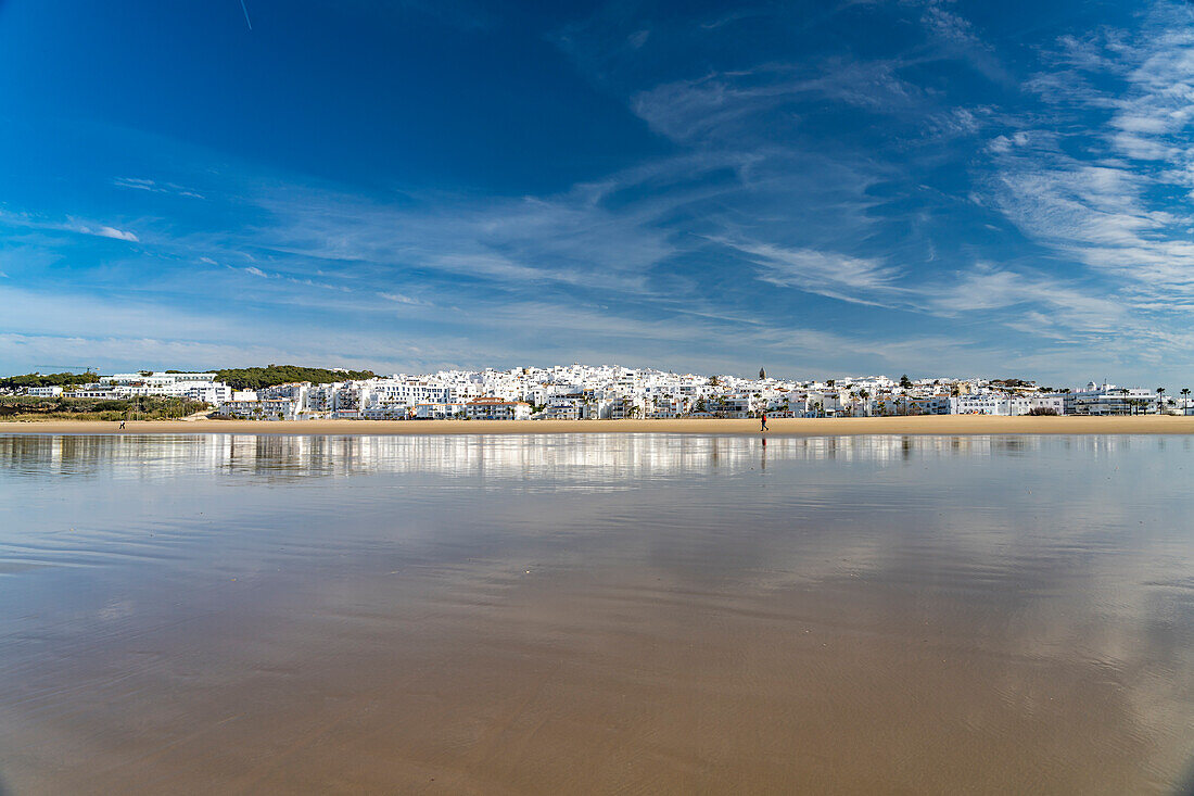 Die Stadtansicht von Conil spiegelt sich am Strand Playa De Los Bateles, Conil de la Frontera, Costa de la Luz, Andalusien, Spanien