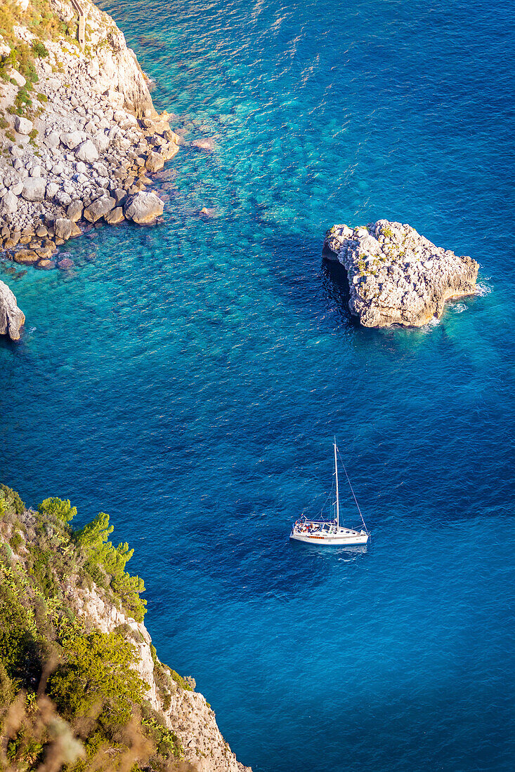 Sailboat in blue bay at the Faraglione Rocks on Capri, Capri Island, Gulf of Naples, Campania, Italy