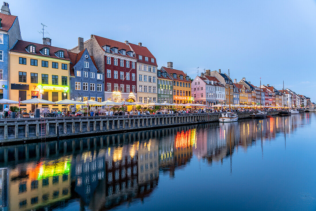 Colorful houses, restaurants and historic ships at Nyhavn canal and harbor at dusk, Copenhagen, Denmark, Europe