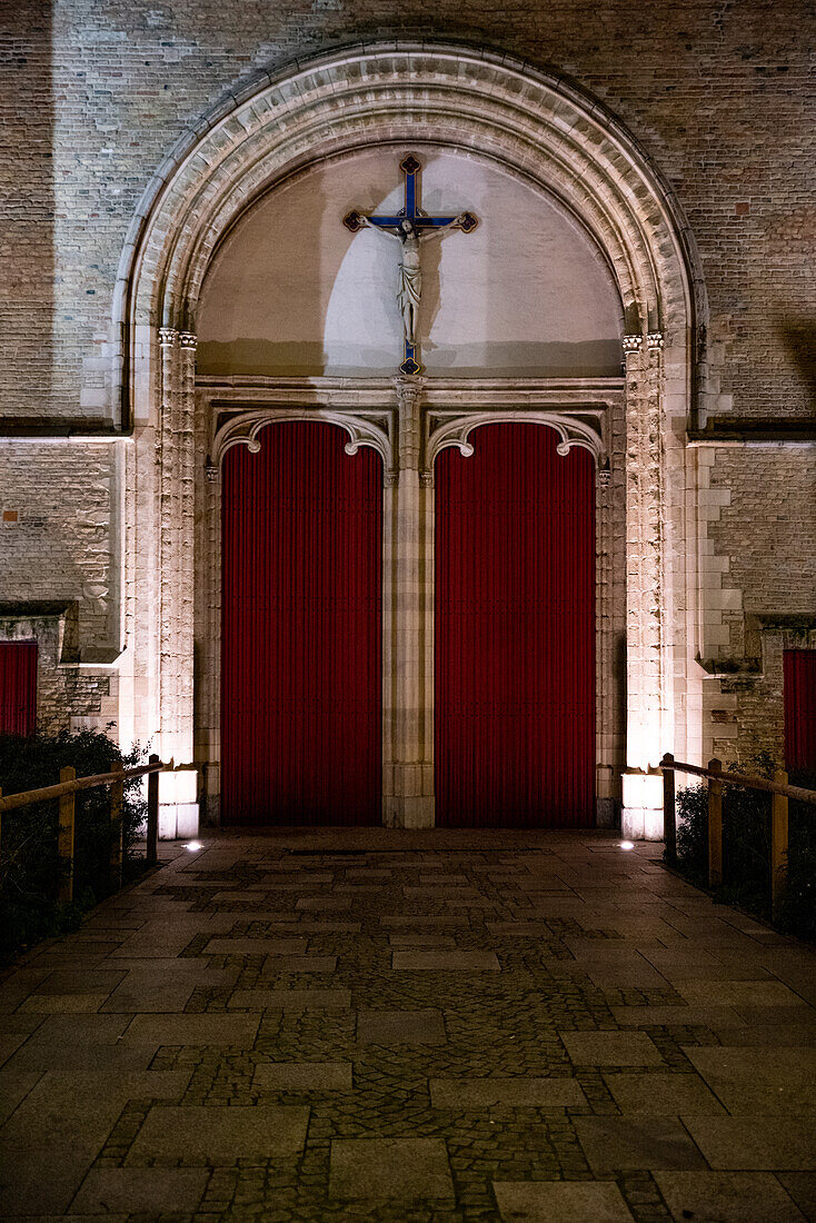 Outside of churchdoors and christ on a cross in Bruges, Belgium