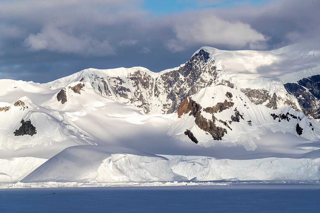 Uferfestes Eis und schneebedeckte Berge in der Wilhamena Bay, Antarktis, Polargebiete