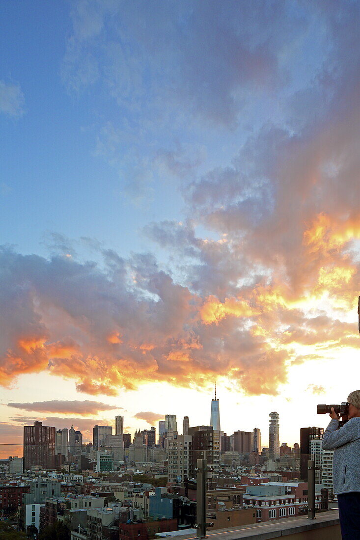 Frau fotografiert von einer Dachterrasse in der Lower East Side die Skyline des Financial Districts von Manhattan, New York, New York, USA