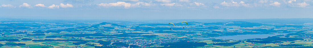 Panorama of the Flachgau with Obetrumer See on the left and Wallersee on the right and two paragliders from the Gaisberg, city mountain of Salzburg, Austria