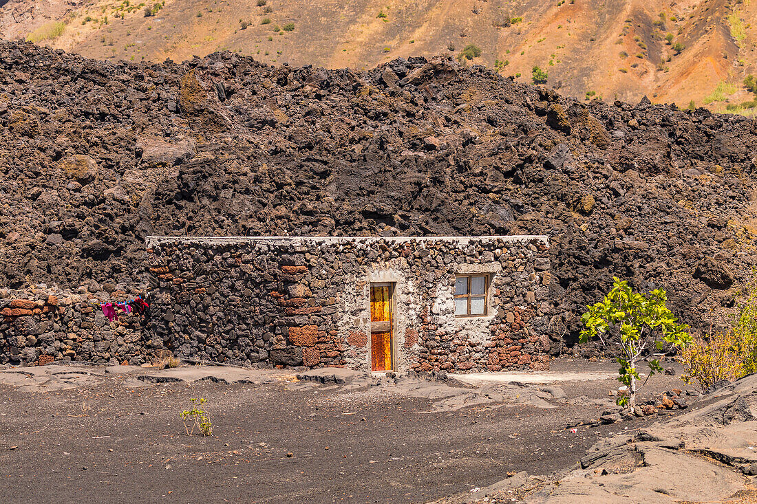 Ein einfaches kleines Steinhaus am Rand vom Lavafluss im Krater des Pico do Fogo, Kapverden