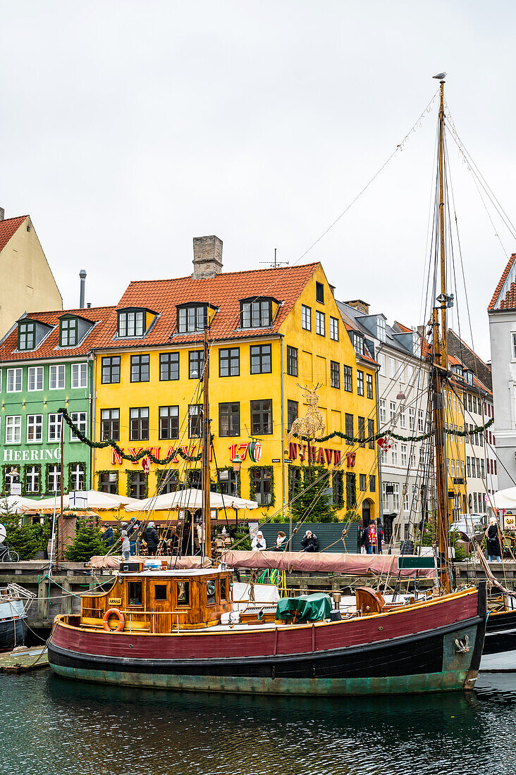 Alter Fischkutter vor den historischen Häusern in Nyhavn, Kopenhagen, Dänemark, Winter